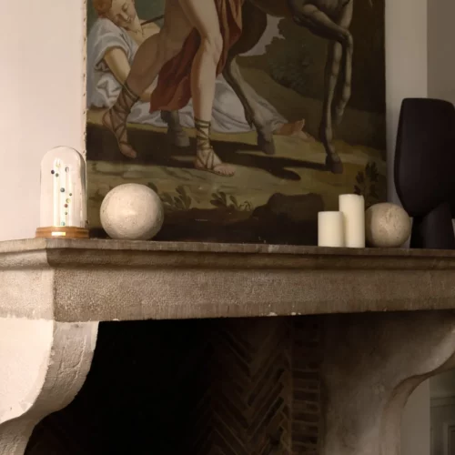 Sympan de mémoire posé sur cheminée, tableau ancien en arrière-plan