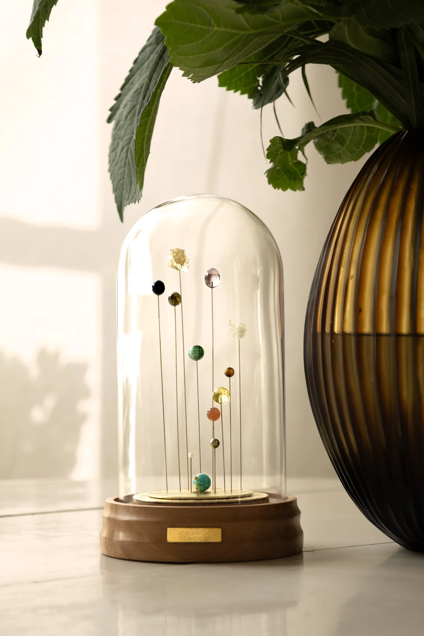 Sympan en pierres planétaires sous globe de verre à côté d’un vase – cadeau exceptionnel anniversaire, œuvre d’art personnalisée qui illumine un lieu de vie.