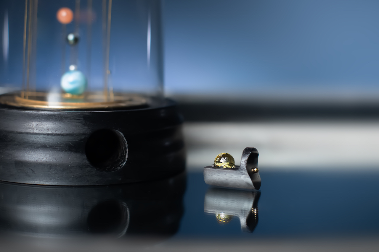 SYMPAN Orbe — le tiroir secret du socle abrite la planète de substitution, préservant l'harmonie du microcosme.
